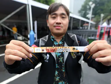 Seorang calon penonton menunjukkan tiket laga FIFA Matchday Timnas Indonesia melawan Argentina di booth penukaran tiket yang terletak di Gedung Serba Guna Senayan, Jakarta, Jumat (16/06/2023). Penukaran tiket Timnas Indonesia Vs Argentina dimulai pukul 10.00-17.00 WIB hingga hari Senin (19/06/2023) siang. (Bola.com/Bagaskara Lazuardi)