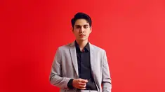 Pesona Maxime Bouttier tak perlu disangsikan lagi. Salah satu foto menampilkannya mengenakan kemeja hitam lengan panjang berbalut setelan jas abu-abu. Kaus kaki hitam dan sepatu pantofel hitam bertali menyempurnakan penampilannya. Auranya makin memancar berkat latar merah polos. Terasa kontras sekaligus menajamkan derajat ketampanan. (Foto: Dok. Instagram @bouttier_maxime)