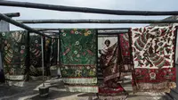 Seorang pekerja menjemur batik di pabrik "batik" kain tradisional Indonesia di Sidoarjo, Jawa Timur (12/11/2019). UNESCO menetapkan batik sebagai karya agung lisan dan warisan budaya takbenda kemanusiaan. (AFP Photo/Juni Kriswanto)