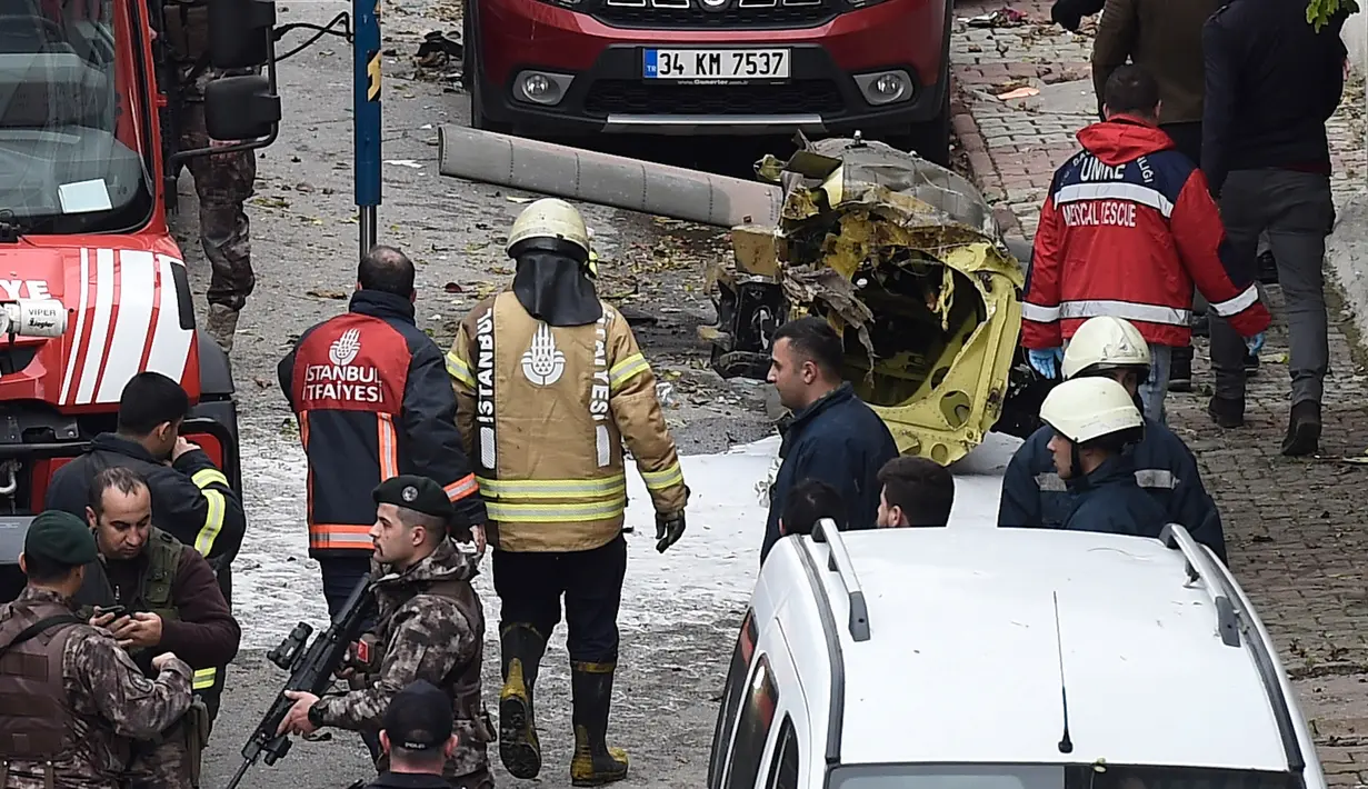 Puing-puing dari helikopter militer yang jatuh berserakan di tanah di lingkungan perumahan di Istanbul, Turki, Senin (26/11). Penyebab kecelakaan helikopter yang menewaskan empat dari lima tentara di dalamnya itu belum diketahui. (AP/Emrah Gurel)