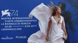 Ekspresi Gaia Trussardi ketika gaun yang dikenakannya tertiup angin saat menghadiri "Penghargaan Franca Sozzani" selama Festival Film Venice ke-74 di Venice Lido (1/9). (AFP Photo/Tizianaa Fabi)