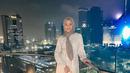 Berpose dengan latar belakang rooftop sebuah gedung, Dara Arafah tampil anggun dalam balutan gamis bermotif dan hijab segi empat warna abu-abu. (Instagram/daraarafah).