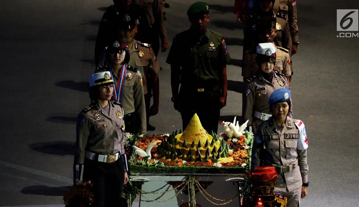 Personel kepolisian membawa tumpeng pada upacara peringatan HUT ke-72 Bhayangkara di Istora Senayan, Jakarta, Rabu (11/7). Dalam acara tersebut, Presiden  Joko Widodo (Jokowi) bertindak sebagai inspektur upacara. (Liputan6.com/Johan Tallo)