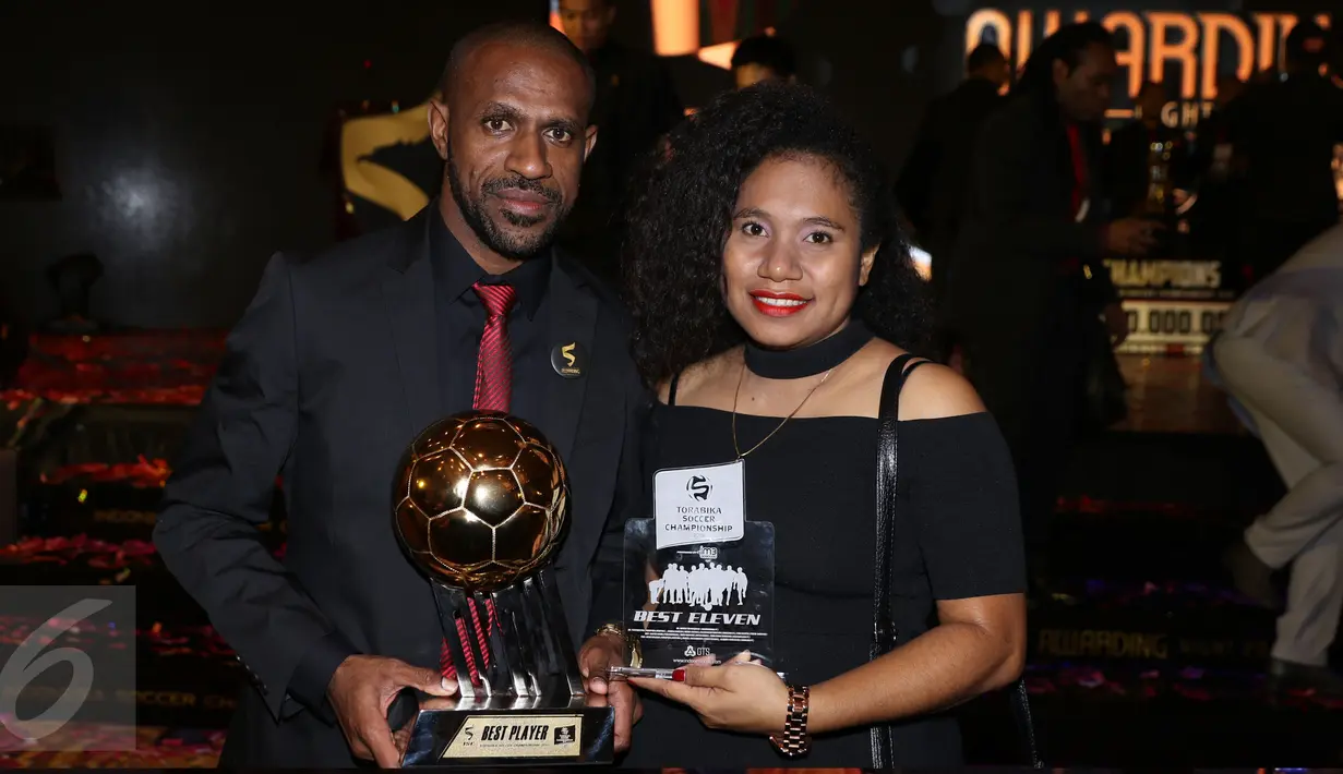 Pemain Persipura Jayapura, Boaz Salossa bersama istri berfoto bersama trophy pemain terbaik ISC 2016 usai malam penghargaan di Bandung, Minggu (8/1). Persipura tampil sebagai tim terbaik sekaligus juara ISC 2016. (Liputan6.com/Helmi Fithriansyah)