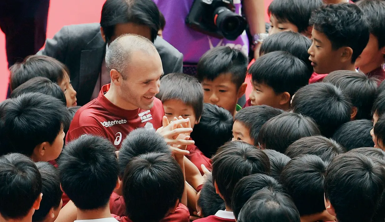 Legenda Barcelona, Andres Iniesta dikelilingi oleh anak-anak selama acara penyambutan di NOEVIR Stadium Kobe, Sabtu (26/5). Iniesta muncul di hadapan publik Jepang sejak menandatangani kontrak bersama Vissel Kobe. (Yohei Nishimura/Kyodo News via AP)