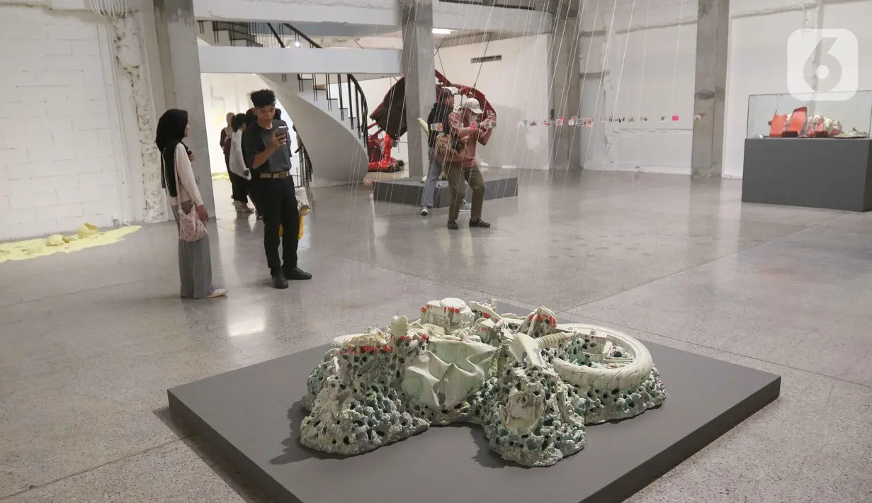Pengunjung memperhatikan pameran foto dan instlalasi di Galeri ROH, Jakarta, Jumat (22/11/2024). (Liputan6.com/Herman Zakharia)