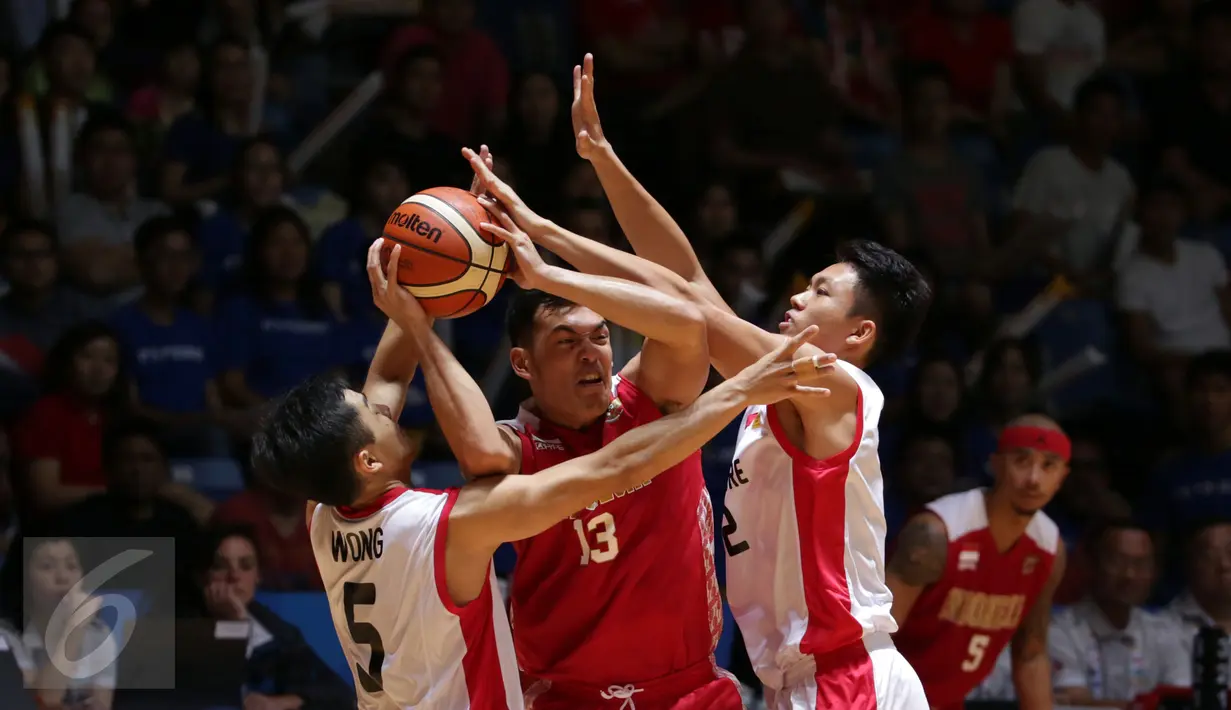 Pebasket Indonesia, Ebrahim Lopez Enguio (tengah) mencoba lolos dari kepungan dua pemain Singapura saat laga semifinal SEA Games ke-28 di OCBC Arena Singapore, Minggu (14/6/2015). Indonesia unggul 87-74 atas Singapura. (Liputan6.com/Helmi Fithriansyah)