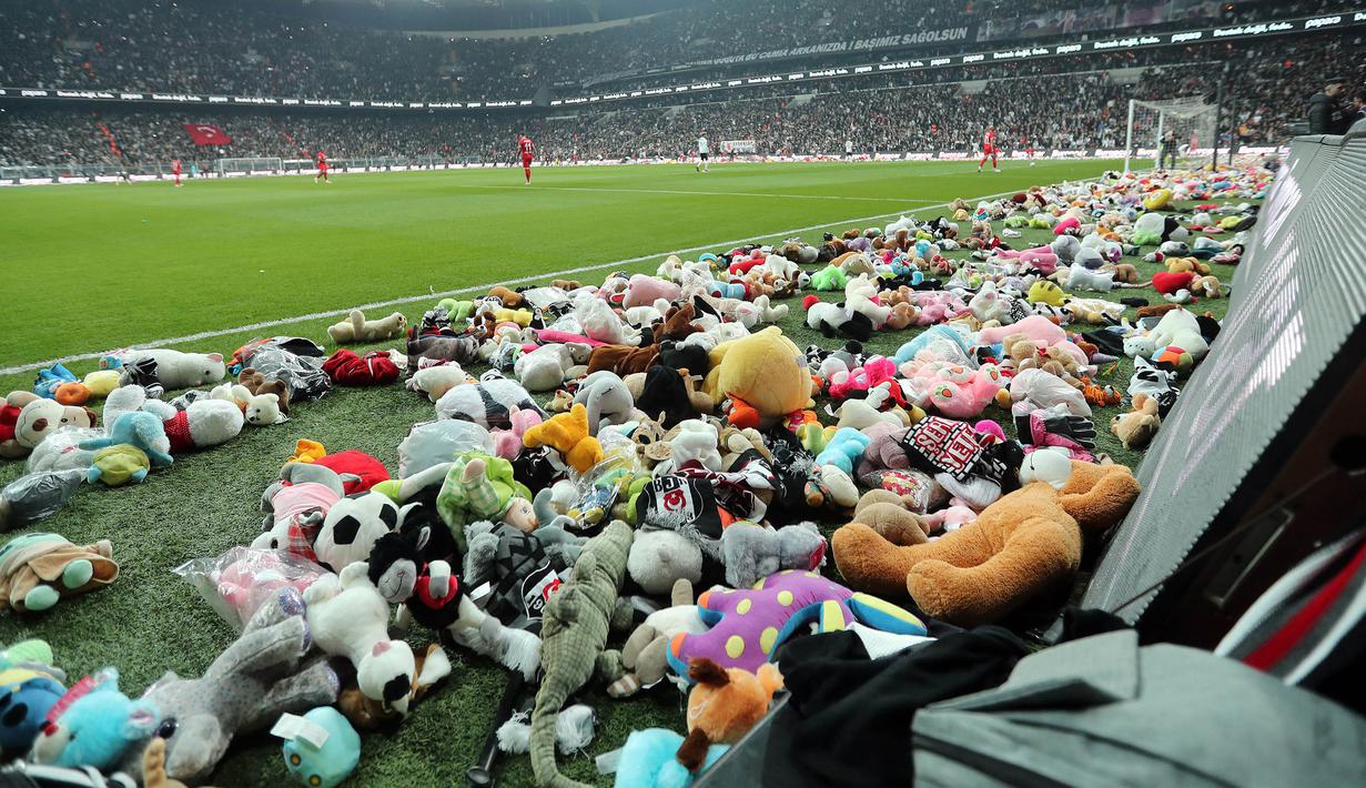 Suasana laga lanjutan Liga Turki 2022/2023 antara Besiktas melawan Antalyaspor yang berlangsung di Stadion Vodafone, Istanbul, Minggu (27/02/2023). Para penonton melakukan aksi lempar boneka ke dalam lapangan sebagai bentuk sumbangan untuk anak-anak korban gempa Turki. (AFP/DHA (DEMIROREN NEWS AGENCY)