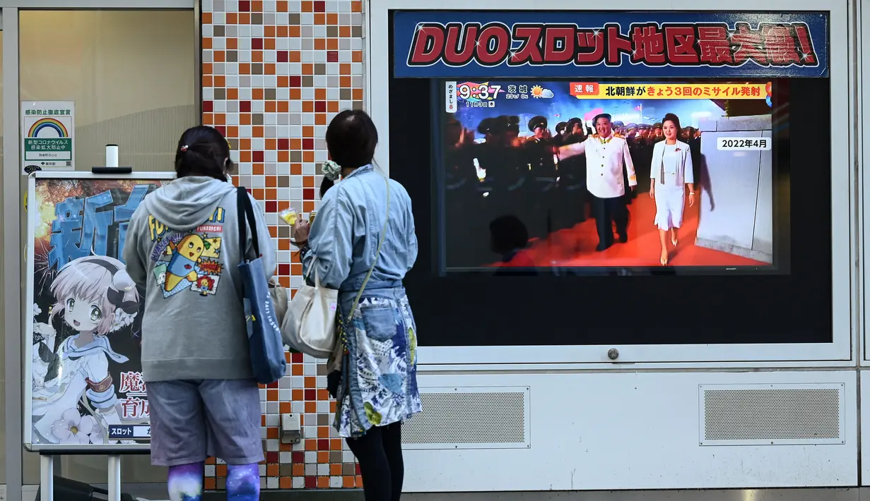 Orang-orang menonton layar televisi yang menampilkan laporan berita tentang peluncuran rudal terbaru Korea Utara dengan gambar Kim Jong Un, di sepanjang jalur pejalan kaki di Tokyo, Kamis (3/11/2022). Peluncuran rudal pagi ini memicu pemerintah Jepang memperingatkan warga di sejumlah prefektur di utara seperti Miyagi, Yamagata, dan Niigata untuk evakuasi ke bunker dan ruang bawah tanah. (Richard A. Brooks / AFP)