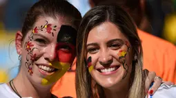 Para suporter menghiasi wajahnya dengan coretan warna bendera Jerman saat laga final piala dunia, Brasil, Senin (14/7/14). (AFP/ODD ANDERSEN)