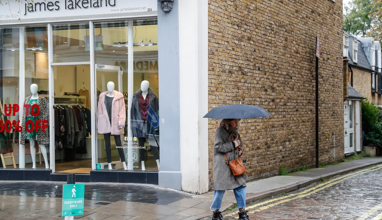 Seorang perempuan berjalan melewati sebuah toko di London, Inggris, pada 13 Oktober 2020. Lonjakan tingkat pengangguran Inggris disebabkan oleh pasar tenaga kerja negara tersebut yang terus terpukul secara signifikan akibat dampak pandemi COVID-19. (Xinhua/Han Yan)