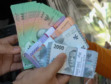 Warga antre untuk menukarkan uang di Pasar Tebet Barat, Jakarta, Selasa (19/3/2024). (Liputan6.com/Herman Zakharia)