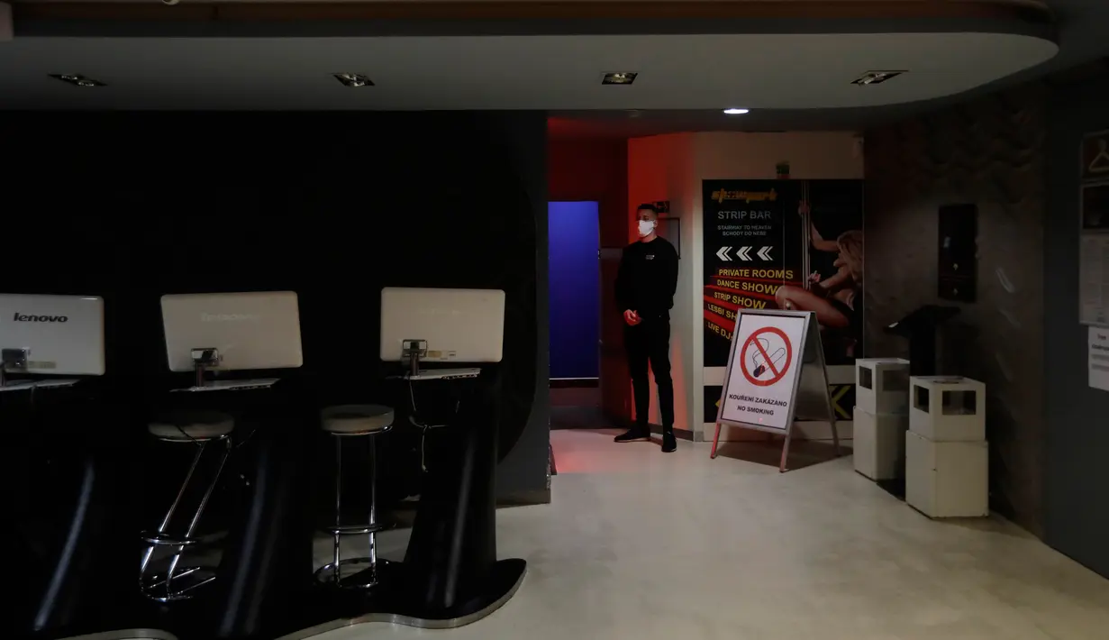Penjaga keamanan berjalan di dalam rumah bordil Showpark yang ditutup di Praha, 30 Maret 2020. Balai kota Praha mempertimbangkan bordil Showpark sebagai tempat berlindung bagi para tunawisma untuk membatasi pergerakan mereka selama keadaan darurat pandemi corona COVID-19. (AP/Petr David Josek)