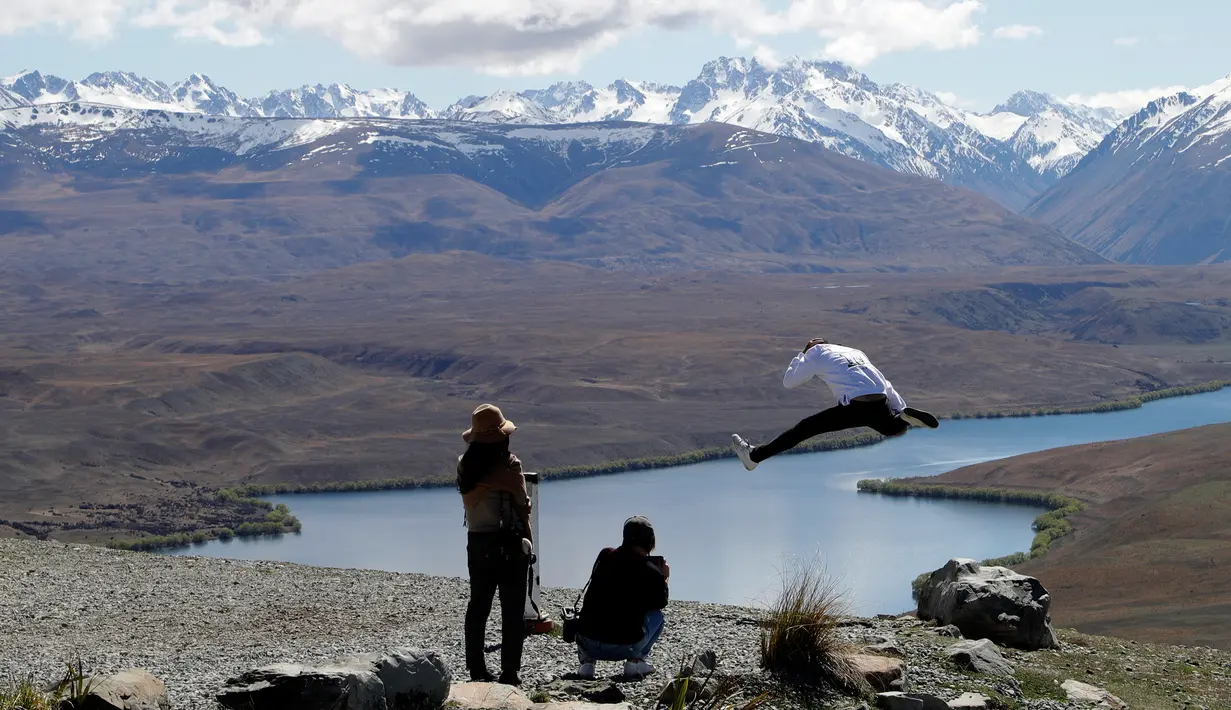 Turis saat mengambil foto di Mount John Observatory di Danau Tekapo, Selandia Baru (6/10). Danau ini mencakup area seluas 83 kilometer persegi (32 sq mi), dan berada di ketinggian 710 meter (2.330 kaki) di atas permukaan laut. (AP Photo/Mark Baker)