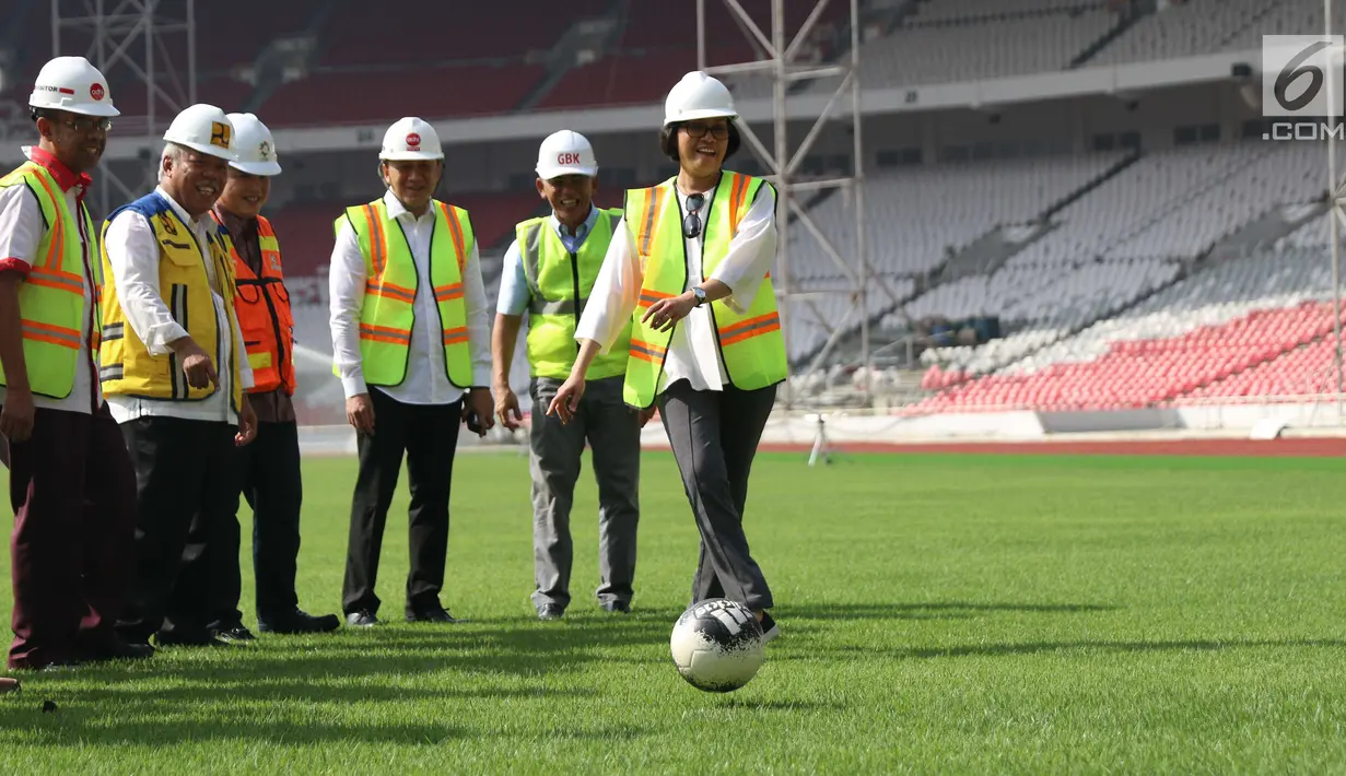 Menteri Keuangan Sri Mulyani Indrawati menendang bola saat menjajal rumput Stadion Utama Gelora Bung Karno di Senayan, Jakarta, Kamis (23/11). Selain meninjau pembangunan, Sri Mulyani juga menjajal rumput di Stadion Utama GBK (Liputan6.com/Angga Yuniar)