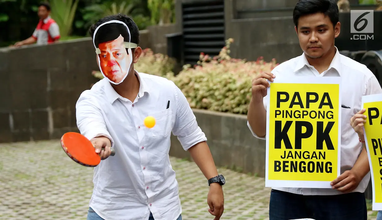 Seorang aktivis mengenakan topeng Setya Novanto melakukan aksi teatrikal bermain tenis meja melawan KPK saat melakukan aksi di depan gedung KPK, Jakarta, Rabu (18/10). (Liputan6.com/Angga Yuniar)