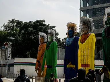 Sejumlah pekerja merapikan ondel-ondel yang dipasang di Taman Ismail Marzuki (TIM), Jakarta, Selasa (22/6/2021). Sebanyak 10 ondel-ondel raksasa setinggi 4,94 meter akan dipamerkan di TIM saat peringatan HUT ke-494 DKI Jakarta yang berlangsung dari 22 hingga 30 Juni 2021 (Liputan6.com/Faizal Fanani)