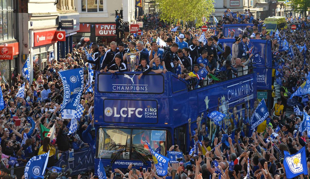 Tima Leicester City berkeliling kota Leicester City dengan trofi Liga Inggris saat disambut ribuan fans, (16/5/2016). (AFP/Glyn Kirk)