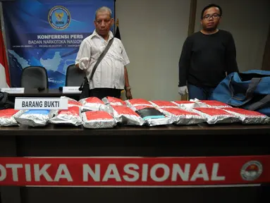 Petugas BNN menghitung jumlah barang bukti yang diperlihatkan saat rilis di Jakarta, Jumat (22/4/2016). BNN berhasil menyita 150.298 butir pil ekstasi dari seorang tersangka di kawasan Pulogebang, Jakarta Timur. (Liputan6.com/Helmi Fithriansyah)