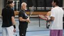 Petenis Stefanos Tsitsipas dari Yunani (kiri) berbicara dengan ayah sekaligus pelatihnya, Apostolos, dan Mark Philippoussis saat sesi latihan menjelang final putra kejuaraan tenis Australia Open 2023 di Melbourne, Australia, Sabtu, 28 Januari 2023. Tsitsipas akan melawan Novak Djokovic dari Serbia di final Minggu 29 Januari. (AP Photo/Dita Alangkara)