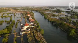 Foto udara suasana Kampung Beting, Desa Pantai Bahagia, Kecamatan Muara Gembong, Bekasi, Jawa Barat, Sabtu (28/8/2021). Menurut penelitian jurnal Environmental Research Letters, kepulauan ini telah mengalami kenaikan air laut rata-rata sebesar 10 milimeter per tahun. (merdeka.com/Imam Buhori)