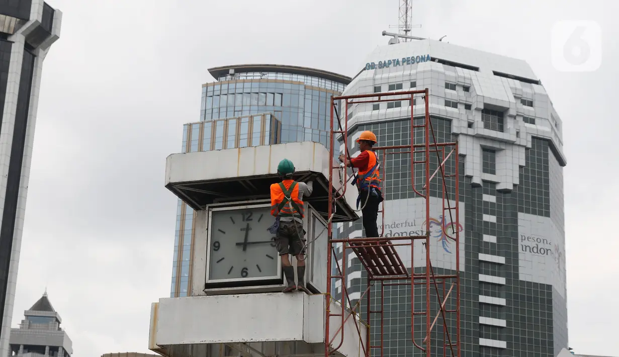 Petugas melakukan perawatan tugu jam yang berada di Merdeka Selatan, Jakarta, Minggu (2/2/2020). Perawatan tersebut dilakukan untuk pengecekan kondisi jam yang nantinya akan dipasangkan panel surya sebagai daya power agar tugu jam dapat berfungsi sebagai petunjuk waktu. (Liputan6.com/Angga Yuniar)