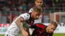 Pemain Bologna, Mitchell Dijks berebut bola dengan gelandang AC Milan, Samuel Castillejo dalam laga pekan ke-35 Liga Italia di San Siro, Senin (6/5/2019). AC Milan berhasil mengatasi Bologna 2-1 demi memelihara asa mereka mengamankan tiket ke Liga Champions musim depan. (AP/Antonio Calanni)