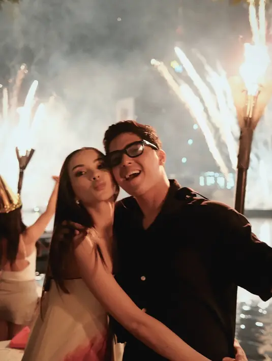 Pasangan selebriti Al Ghazali dan Alyssa Daguise mencuri perhatian dengan penampilan serasi mereka di Bangkok. Alyssa tampil anggun dalam strapless dress putih yang memancarkan aura chic dan sophisticated, sementara Al memilih kemeja hitam simpel namun berkelas. Nuansa hitam putih mereka benar-benar menyatu dengan latar gemerlap kembang api yang menerangi langit kota. [@alghazali7].