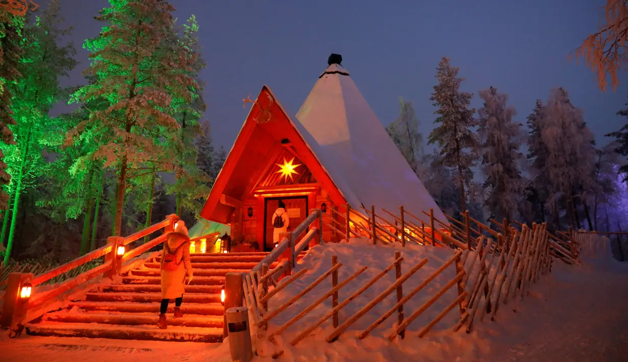 Pengunjung memasuki sebuah restoran di Desa Sinterklas atau Santa Claus Village, di Lingkar Arktik, Finlandia, 15 Desember 2016. Kawasan yang tertutup salju pada musim dingin ini makin menguatkan suasana 'White Christmas'. (REUTERS/Pawel Kopczynski)