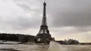 Menara Eiffel terlihat saat sungai Seine di Paris meluap, Prancis (6/1). Sungai Seine tidak mampu menampung debit air setelah hujan terjadi terus-menerus. (AFP Photo/Christophe Simon)