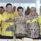 Wapres Jusuf Kalla (tengah) bersama Ketum Partai Golkar versi munas Bali Aburizal Bakrie, Ketum Partai Golkar versi munas Ancol Agung Laksono berjabat tangan setelah penandatanganan kesepakatan islah di Jakarta, Sabtu (30/5). (Liputan6.com/Johan Tallo)
