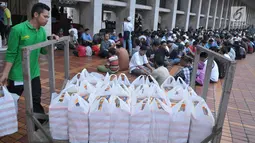 Petugas membagikan takjil jelang berbuka puasa pada hari kedua bulan Ramadan di Masjid Istiqlal, Jakarta, Minggu (28/5). Sebanyak 5000 kotak makanan dibagikan untuk berbuka pada gari Jumat - Minggu. (Liputan6.com/Helmi Afandi) 