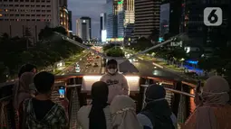 Warga berfoto di balkon Jembatan Penyeberangan Orang dan Sepeda (JPOS Phinisi) di kawasan Karet, Jakarta, Minggu (20/3/2022). JPOS Phinisi kini menjadi objek baru bagi warga Jakarta. (Liputan6.com/Faizal Fanani)