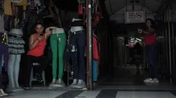 Seorang wanita bermain ponsel di sebuah toko selama pemadaman listrik di San Cristobal, Venezuela (26/3). Ponsel yang selalu aktif digunakan untuk berkomunikasi maupun sebagai penerangan darurat sulit untuk bertahan tanpa adanya listrik. (Reuters/Carlos Eduardo Ramirez)
