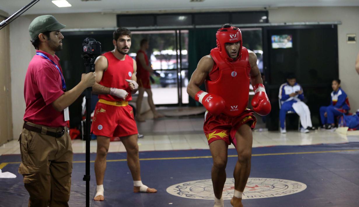 Atlet Wushu Asal Iran, melakukan pemanasan sebelum bertanding pada Cabang Sanda Kejuaraan Dunia Wushu 2015 di Istora, Senayan, Jakarta,Rabu (18/11/2015). (Bola.com/Nicklas Hanoatubun)
