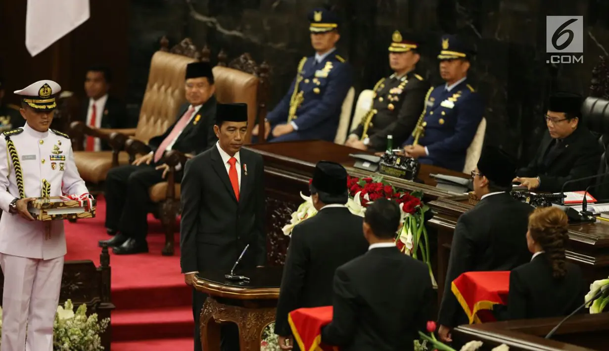 Presiden Joko Widodo disaksikan Ketua DPD RI Oesman Sapta Odang dan Wakil Ketua DPR Fadli Zon bersiap menandatangani Nota Keuangan dan RAPBN 2018 di Kompleks Parlemen, Senayan, Jakarta, Rabu (16/8). (Liputan6.com/Johan Tallo)