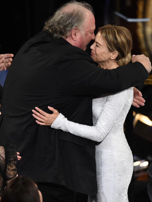 John Carrabino memberikan ucapan kepada Renee Zellweger sebelum menaiki panggung untuk menerima piala Oscar pada Academy Awards ke-92 di Dolby Theatre, Los Angeles, Minggu (9/2/2020). Renee Zellweger menyabet penghargaan sebagai Aktris Terbaik lewat perannya di film 'Judy'. (AP Photo/Chris Pizzello)