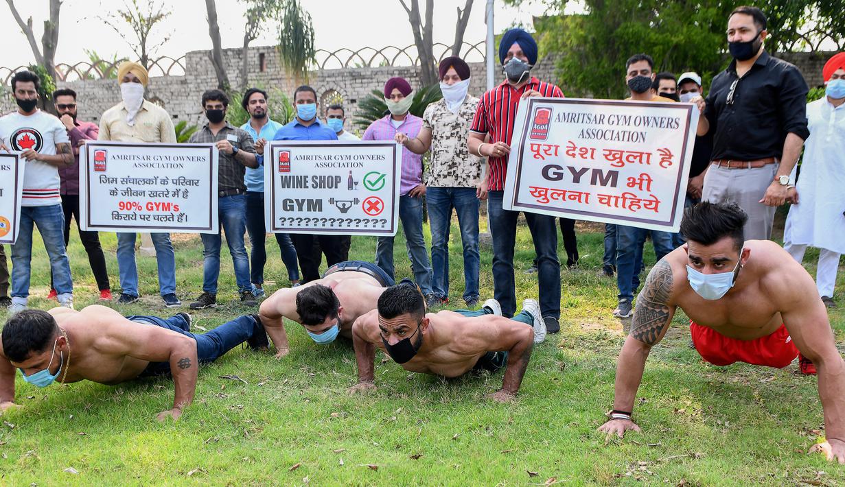 Pemilik dan pelatih gym memegang spanduk saat protes menuntut pemerintah membuka kembali pusat kebugaran di Amritsar, India, Minggu (7/6/2020). Mereka meminta aktivitas tempat olahraga gym juga diizinkan buka setelah pelonggaran lockdown, bukan hanya kegiatan perekonomian. (NARINDER NANU/AFP)