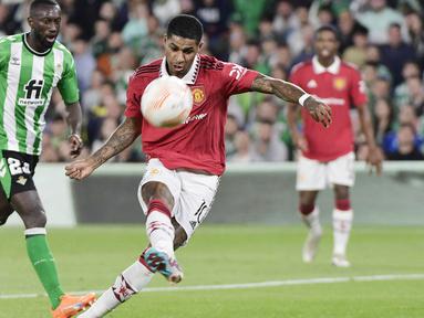 Pemain Manchester United, Marcus Rashford, melepaskan tendangan saat melawan Real Betis pada leg kedua babak 16 besar Liga Europa di Stadion Benito Villamarin, Jumat (17/3/2023). Manchester United melangkah dengan tegas ke perempat final atau 8 besar Liga Europa 2022-2023. (AFP/Cristina Quicler)
