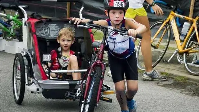 Bantu saudaranya yang tidak bisa berjalan di lomba triathlon