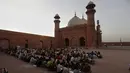 Orang-orang berbuka puasa selama bulan suci Ramadhan di masjid bersejarah Badshahi, di Lahore, Pakistan (3/4/2022). Masjid Badshahi berkapasitas 5000 jemaah di ruang sholat utamanya dan 95.000 jemaah di halaman tengah serta portiko. (AP Photo/K.M. Chaudary)
