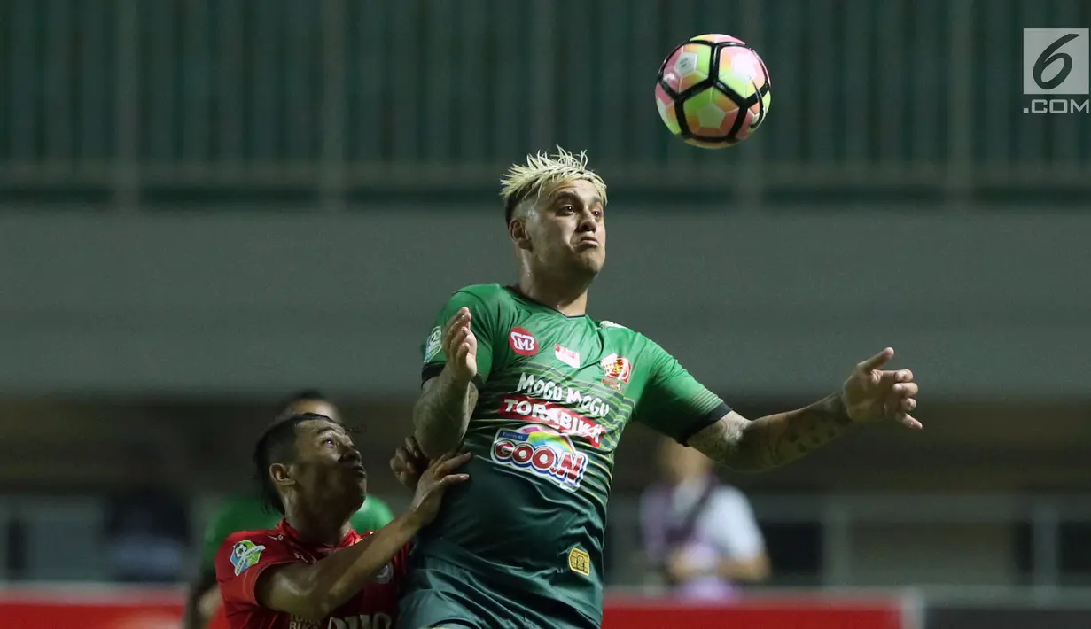 Pemain depan PS TNI, Leonel Jorge Nunez (kanan) berebut bola dengan pemain Arema FC dilanjutan Liga 1 Indonesia di Stadion Pakansari, Bogor, Senin (3/7). Laga kedua tim berakhir imbang 0-0. (Liputan6.com/Helmi Fithriansyah)