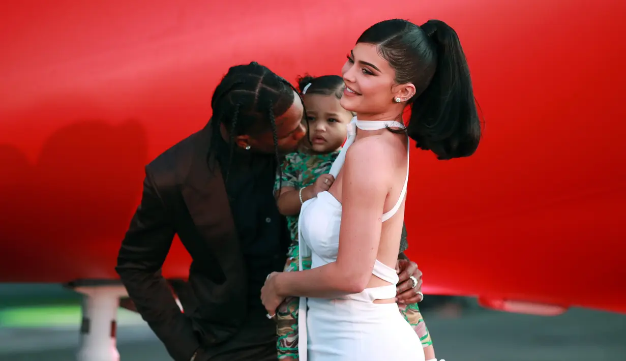 Travis Scott (kiri) berpose bersama Kylie Jenner (kanan) dan anak mereka Stormi Webster (tengah) saat menghadiri pemutaran perdana Netflix "Travis Scott: Look Mom I Can Fly" di Barker Hangar, Santa Monica, California, Amerika Serikat, Senin (27/8/2019). (Rich Fury/GETTY IMAGES NORTH AMERICA/AFP)