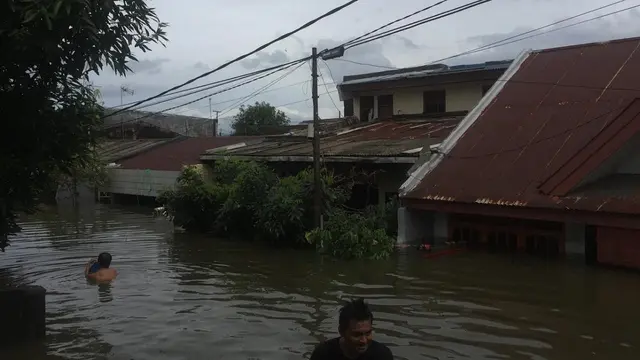 Warga korban banjir di blok 8 Perumnas Antang, Makassar manfaatkan ban bekas dan jerigen sebagai pelampung (Liputan6.com/ Eka Hakim)