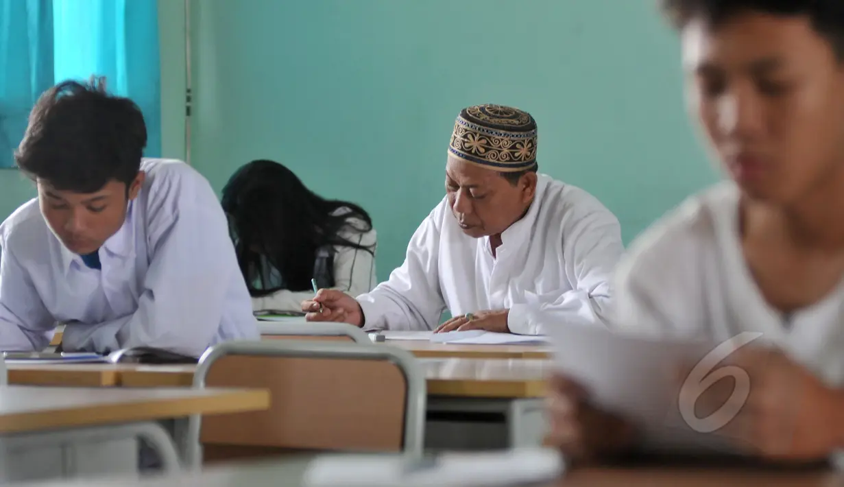 Seorang pria tampak sedang mengerjakan soal Ujian Nasional (UN) kesetaraan paket B di SMPN 80 Jakarta, Senin (4/5/2015). Sebanyak 378 peserta, termasuk peserta berusia lanjut mengikuti UN di hari pertama tersebut. (Liputan6.com/Johan Tallo)