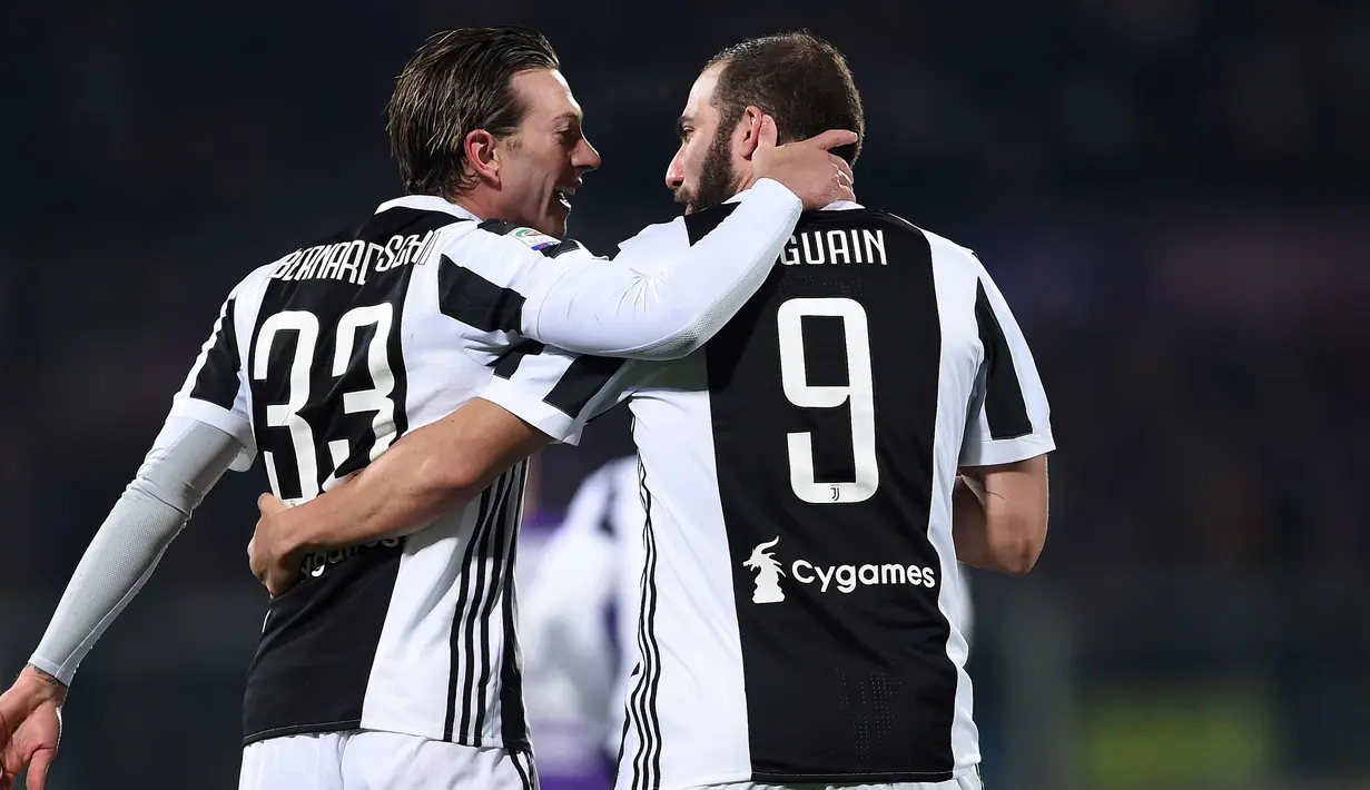 Gelandang Juventus, Federico Bernardeschi (kiri) berselebrasi bersama rekannya Gonzalo Higuain usai mencetak gol ke gawang Fiorentina di Liga Serie A Italia di stadion Atemio Franchi, Florence (9/2). Juventus menang 2-0. (AFP Photo/Filippo Monteforte)