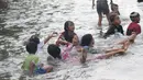 Sejumlah anak-anak bermain di genangan air akibat banjir rob di kawasan pintu masuk Pelabuhan Nizam Zachman, Muara Baru, Jakarta, Jumat (5/6/2020). Banjir rob di Pelabuhan Muara Baru tersebut terjadi akibat cuaca ekstrem serta pasang air laut. (Liputan6.com/Helmi Fithriansyah)