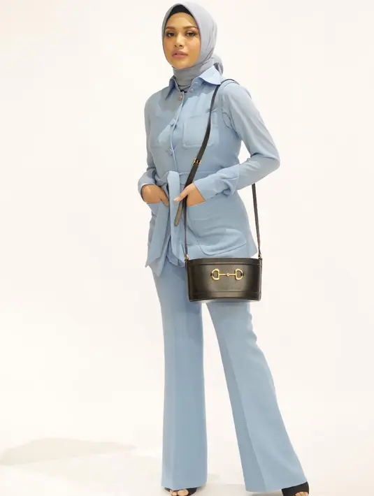Satu lagi tampilan formal yang manis dari Aurelie Hermansyah. Dengan setelan kemeja biru dan celana berwarna senada, ia padukan dengan sling bag hitam dan jilbab bernuansa abu-abu muda. Foto: Instagram.
