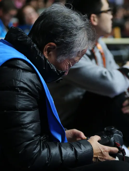 Fotografer Hong Nanli memeriksa kamera selama pertandingan basket di Shanghai (16/1). Karir nenek Hong Nanli dimulai sebagai pesenam, kemudian pada 1959 ia menjadi guru senam hingga menjadi juri senam internasional. (AFP Photo/China Out)