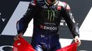 Pembalap Yamaha Fabio Quartararo memegang bendera Swiss untuk menghormati pembalap Swiss Jason Dupasquier (19) yang tewas dalam kecelakaan saat upacara podium di akhir MotoGP Mugello di Sirkuit Mugello, Scarperia, Italia, Minggu (30/5/2021). (AP Photo/Antonio Calanni)